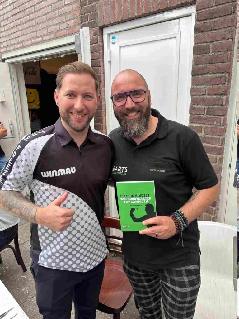 Joppe Bakens met zijn boek naast een speler.