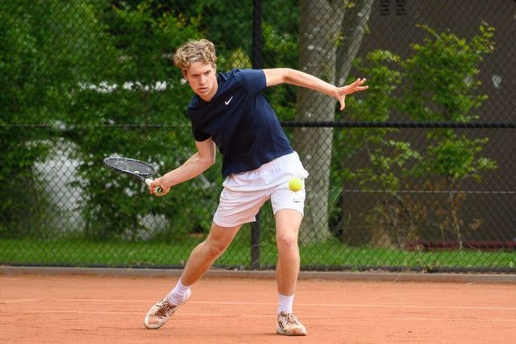 Tenniser Bart Wolvius slaat een bal op de tennisbaan