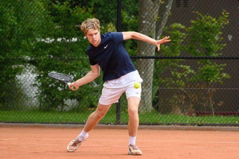 Tenniser Bart Wolvius slaat een bal op de tennisbaan
