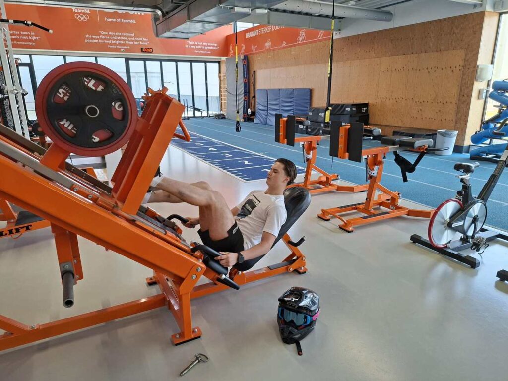 Motorcrosser Dean Gregoire traint zijn benen op een beenpers tijdens een krachttraining in een sportschool in Eindhoven.