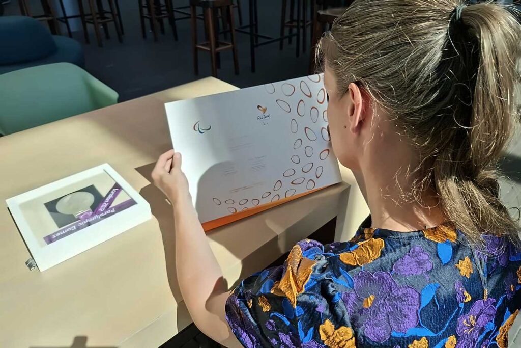 Amy Siemons bekijkt het diploma dat ze tien jaar na de Paralympics van Rio 2016 voor het eerst ziet.