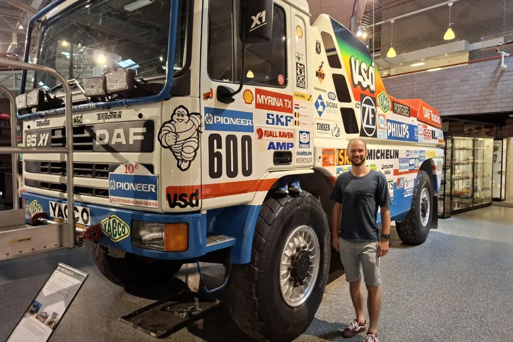 Thijs van den Berg naast de DAF 95 X1 Dakartruck met startnummer 600 in het DAF Museum.