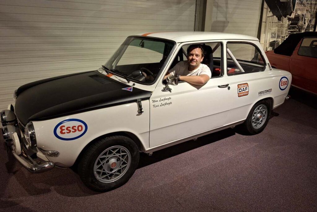 Willem Luijbregts achter het stuur van de witte DAF-rallyauto van Wim en Kees Luijbregts uit 1973.